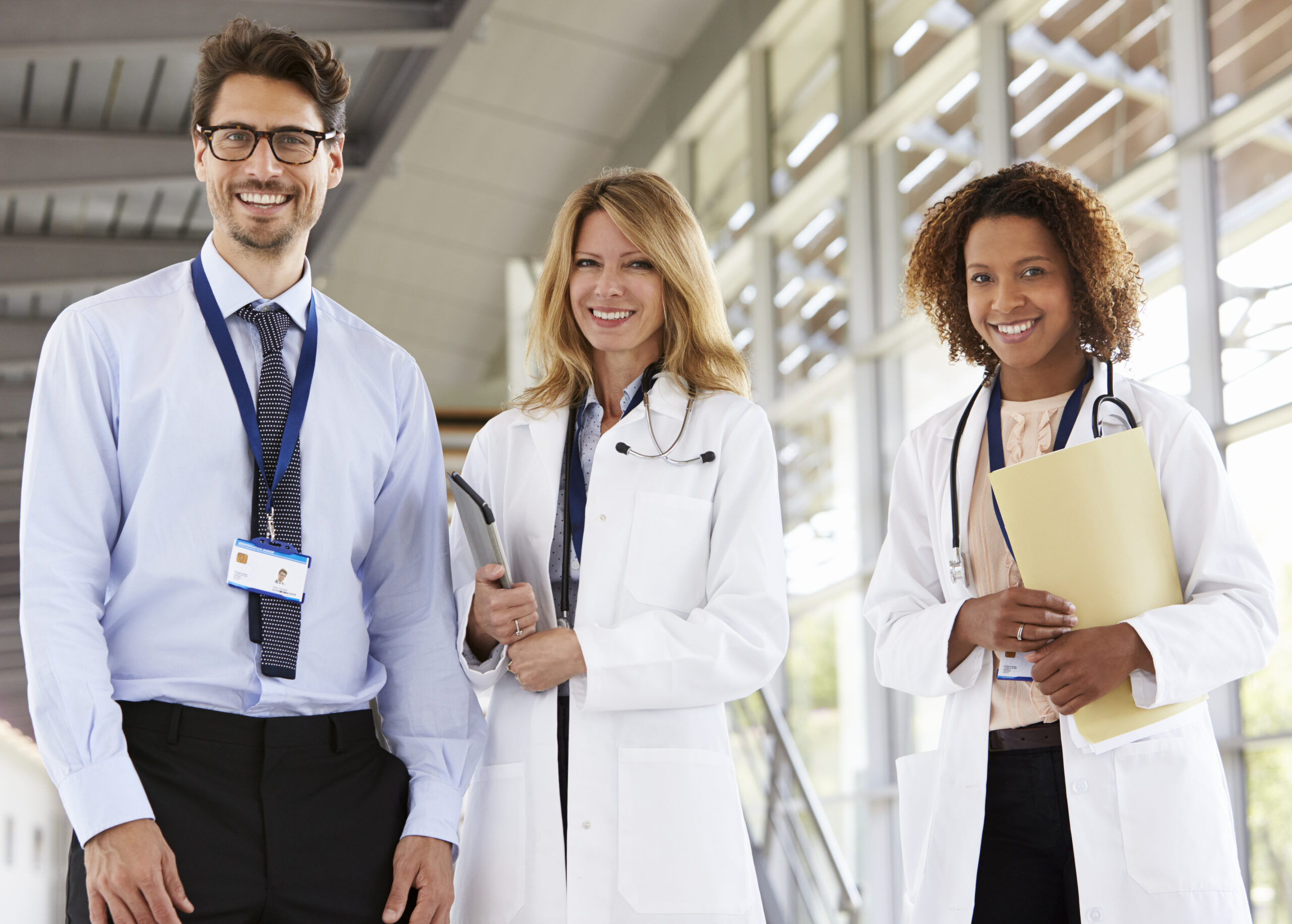 Portrait of three male and female doctors, looking to camera